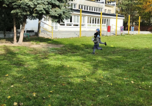 Na zdjęciu widzimy dzieci, które sowbodnie biegają po ogrodzie przedszkolnym.