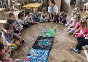 W kręgu dzieci wraz z prowadzącą omawiają powstałe obrazki i temat zajęć