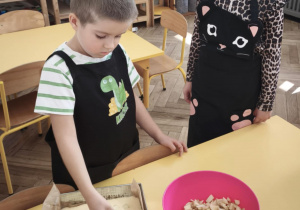 Dziecko układa jabłka na cieście