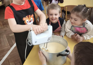 Dziecko miksuje jajka z cukrem