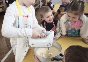 Dziecko miksuje jajka z cukrem