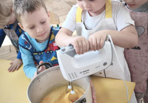 Dziecko miksuje jajka z cukrem