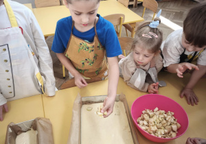 Dziecko układa jabłka na cieście