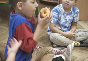 Dzieci wąchają i oglądają jabłko