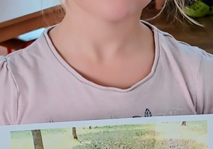 Dziewczynka pokazuje zdjęcie swojego psa.