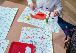 Dziewczynka robi psa z papieru.