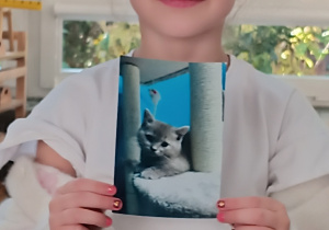 Dziewczynka pokazuje zdjęcie swojego kota.