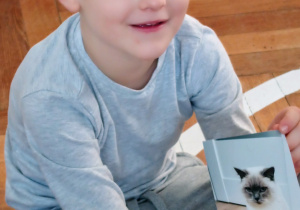 Chłopiec pokazuje zdjęcie swojego kotka.