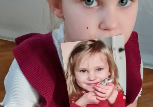 Dziewczynka pokazuje zdjęcie swojego chomika.