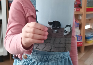 Dziewczynka pokazuje zdjęcie swojego kota.