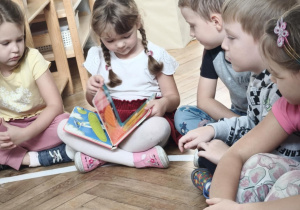 Dziewczynka ogląda książkę Tobiasza