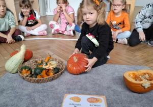 dziewczynka trzyma w ręku dynię ozdobną