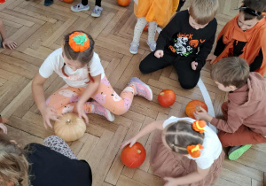 dzieci kręcą dyniami na podłodze