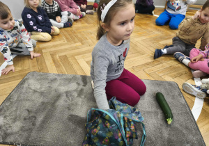 Na zdjęciu widzimy dziewczynkę, której zadaniem jest wyciągnąć warzywo z torby.