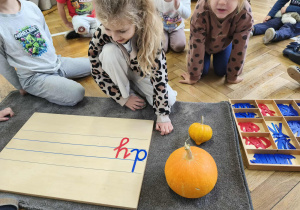 Na zdjęciu widzimy dziewczynkę, która wyszukała literę "y" i położyła ją na liniaturze.