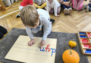 Na zdjęciu widzimy chłopca, który z ruchomego alfabetu wyszukał głoskę "n".