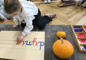 Na zdjęciu widzimy dziewczynkę, która tworzy wyraz "dynia", wykorzystując ruchomy alfabet.