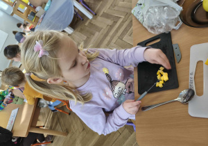 Na zdjęciu widzimy dziewczynkę, która kroi dynię.