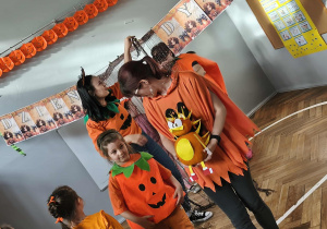 Na zdjęciu widzimy dzieci ich rodziców podczas pierwszej zabawy "Pokaz mody i dyniowego stworka".