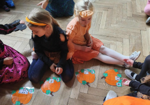 Na zdjęciu widzimy dzieci, które uczestniczą w zabawie "Liczymy pestki dyni".