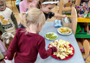 Dzieci częstują się owocami.