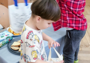 Chłopiec rozdaje upominki dzieciom.