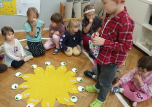 Chłopiec w koronie stoi w środku koła.