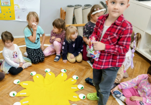 Chłopiec w koronie stoi w środku koła.