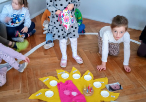 Dziewczynka stoi na środku koła.