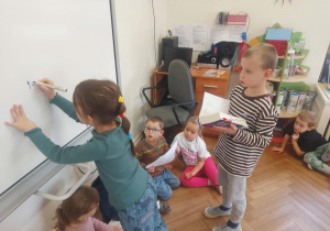 dzieci odczytują liczbę ilości stron jednej z ksiąg i próbują ją odczytać