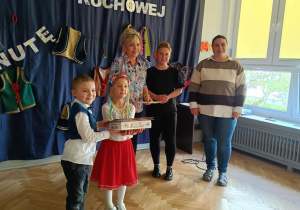 Zdjęcie przedstawia dwoje dzieci z nagrodami oraz trzy nauczycielki pozujących do zdjęcia.
