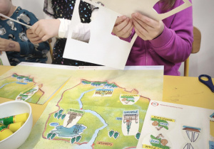 Dzieci uzupełniają kartę pracy o Polsce