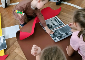 Chłopiec przykleja ilustrację do symbolicznego domu.