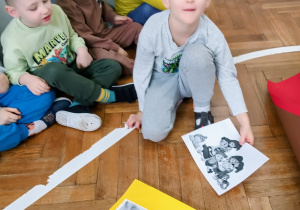 Chłopiec pokazuje wylosowaną prze siebie ilustracje.