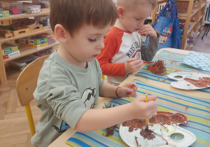 chłopiec, który maluje swojego jeża farbą.