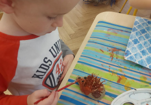 drugi etap pracy. Wyschnięte jeże dzieci malują farbą
