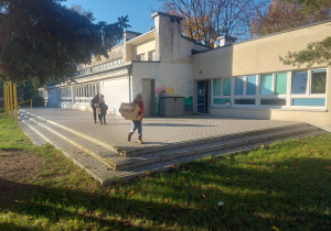 dzieci wynoszą domek do ogrodu