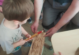 chłopiec wbijający gwoździe