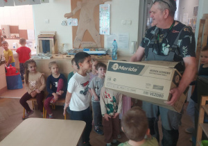 Pan Jacek z wielkim pudłem w którym znajdują się elementy domku dla jeża