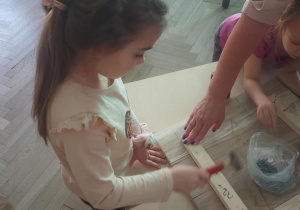 dziewczynka łączy elementy dachu