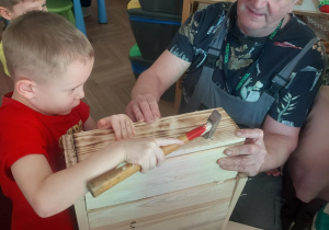 chłopiec wbijający gwoździe