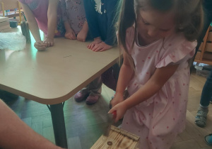 dziewczynka wbijająca gwoździe