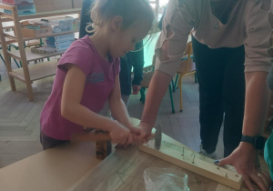 dziewczynka z nauczycielem łączą elementy dachu