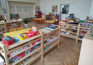 na zdjęciu widać salę przedszkolną grupy trzeciej, niskie regały z materiałem rozwojowym dla dzieci