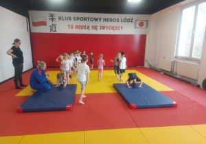 dzieci ćwiczące przewrót w przód