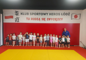 Zdjęcie grupowe w klubie sportowym z trenerem judo