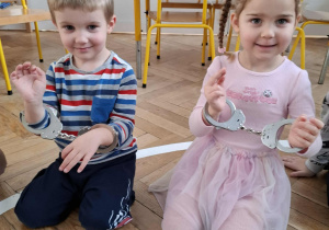 dzieci przymierzają kajdanki