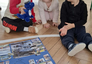 dzieci patrzą na maskotkę krakowskiej policji