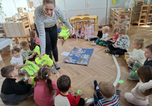 kobieta wręcza dzieciom odblaski