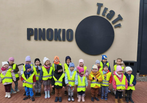 Na zdjęciu widzimy grupkę dzieci, które staoją przed budynkiem Teatru Pinokio.